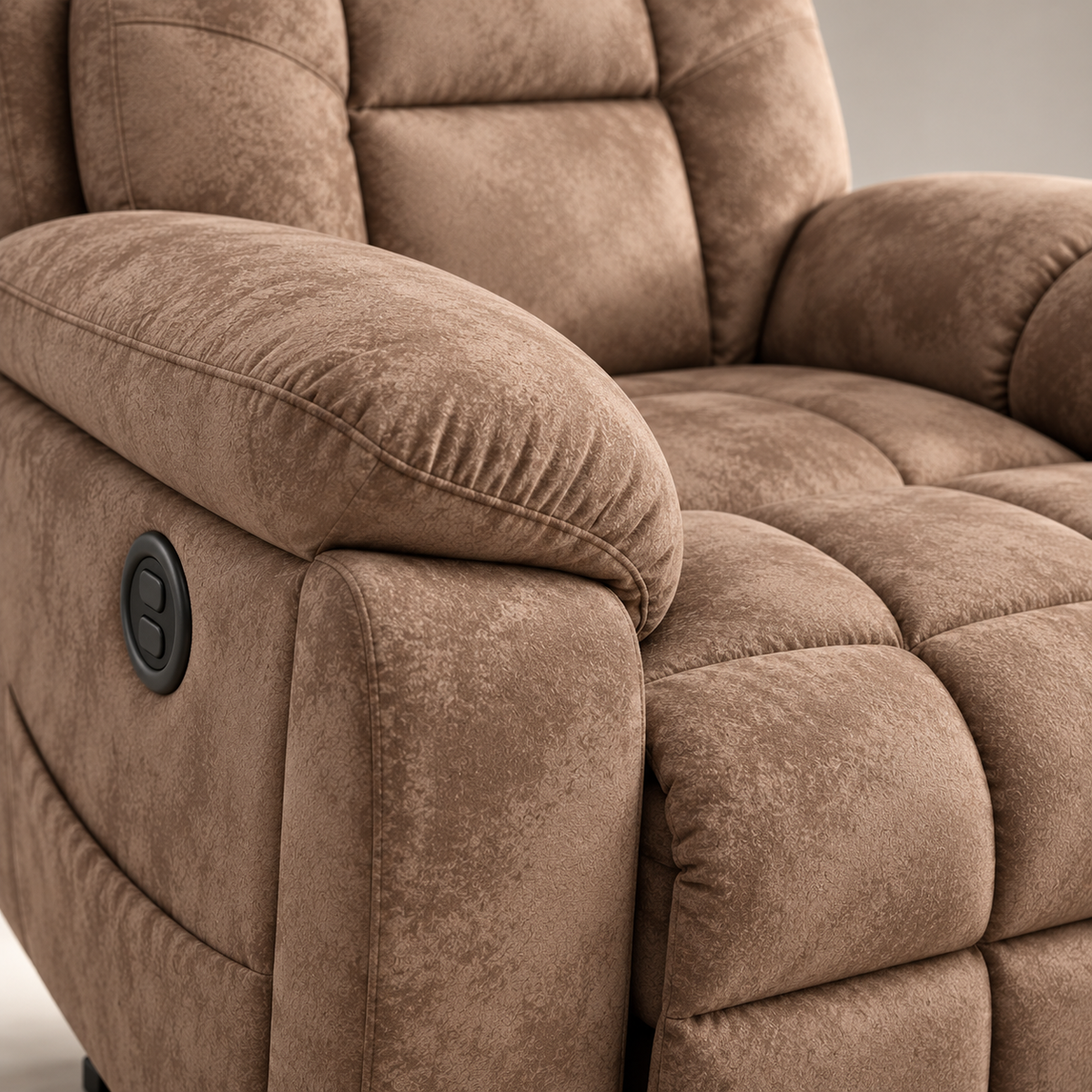 Close-up of the plush padded armrest and side-mounted control button on the tan recliner