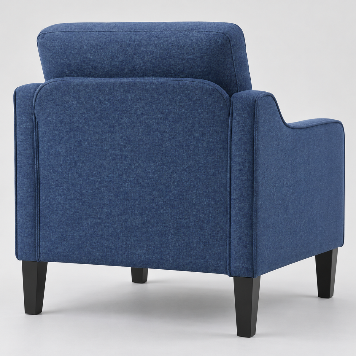 Rear three-quarter view of the navy accent chair showing the back and tapered legs